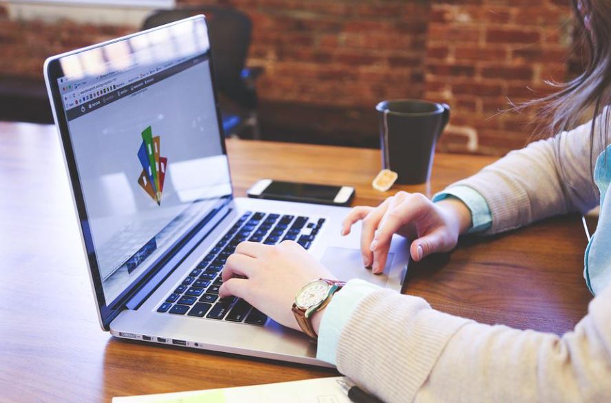 Mulher lendo o brandbook em uma tela de computador